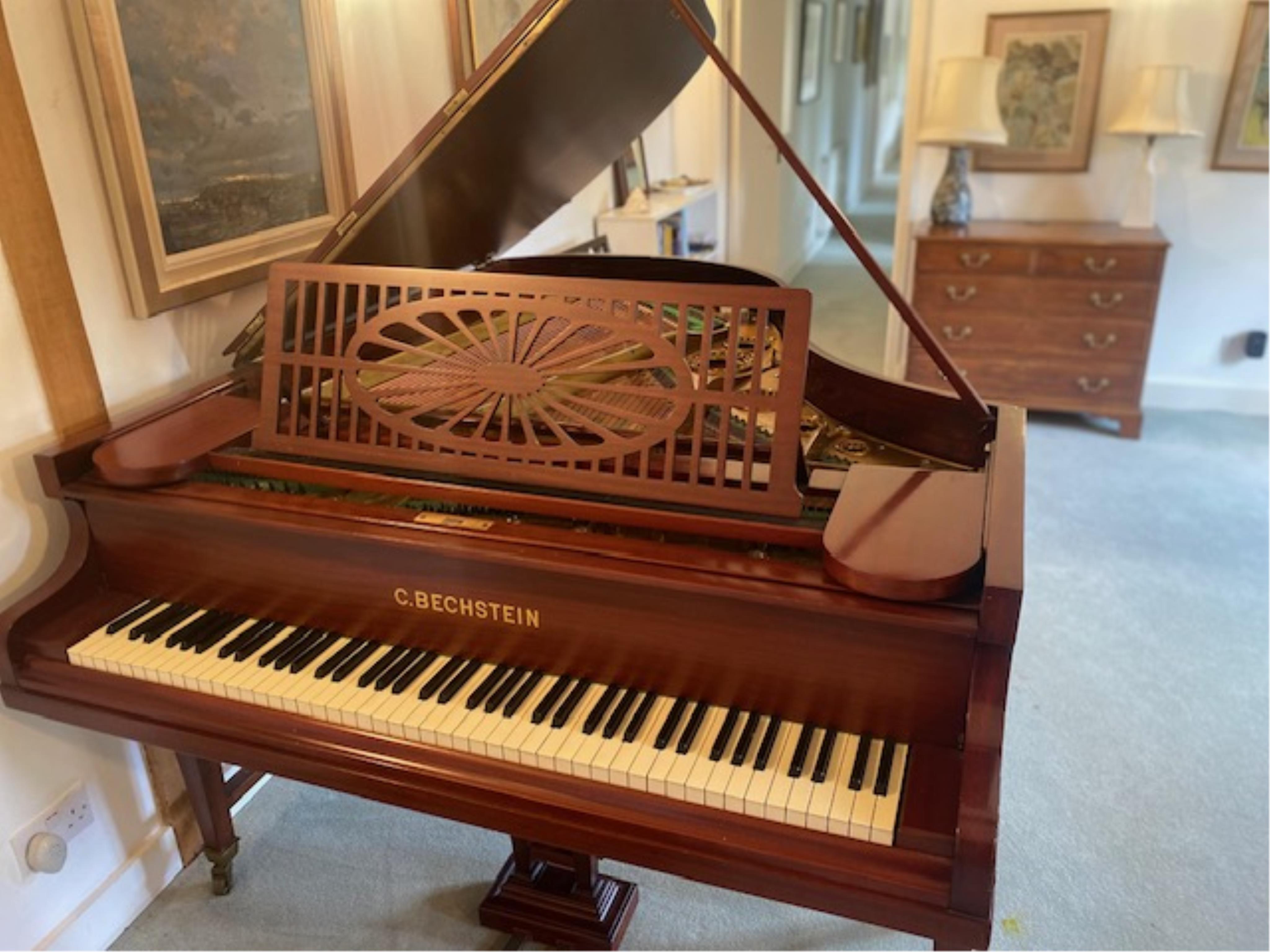 A Bechstein mahogany cased boudoir grand piano, model A, number 96003 (c.1910). Recently restrung, new felt to hammers and case re-polished, together with an adjustable ebonised piano stool. Length 182cm, depth 144cm.